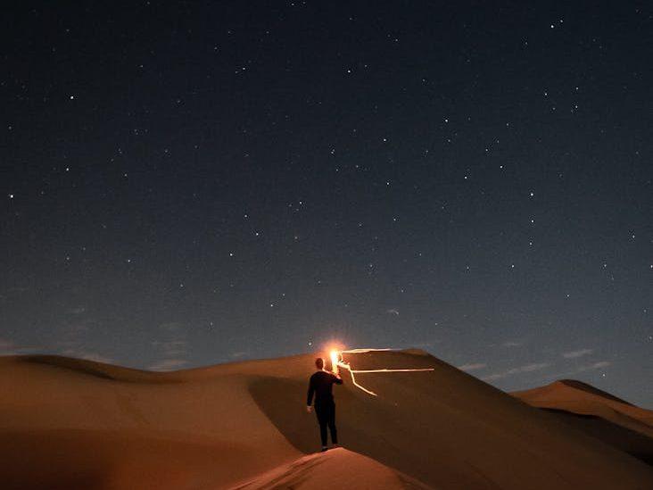 person standing in the desert during night time, evoking: Sagittarius, Sagittarius season, Hellenistic astrology, Zodiac, and wisdom