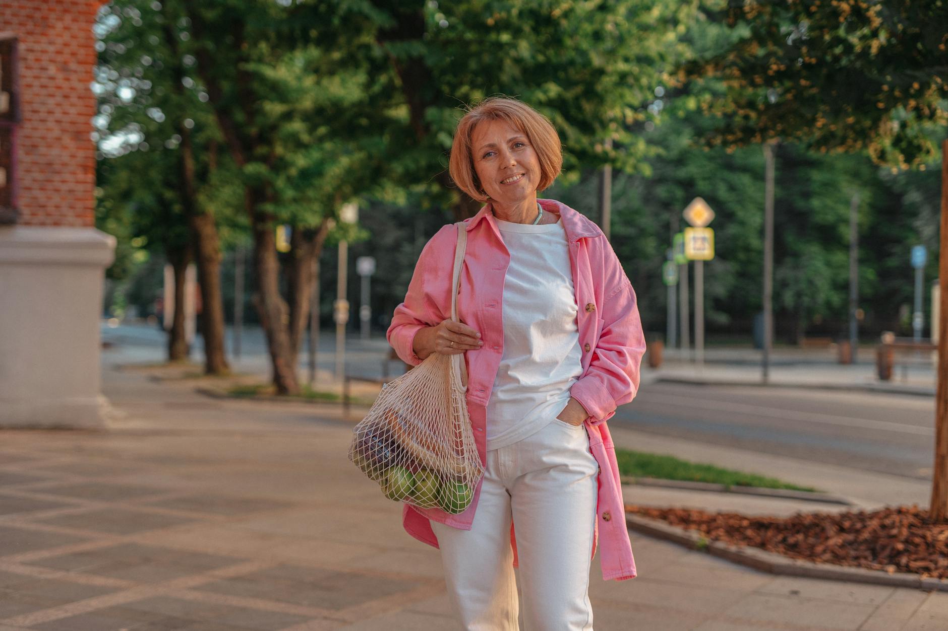 a woman carrying a mesh bag with groceries