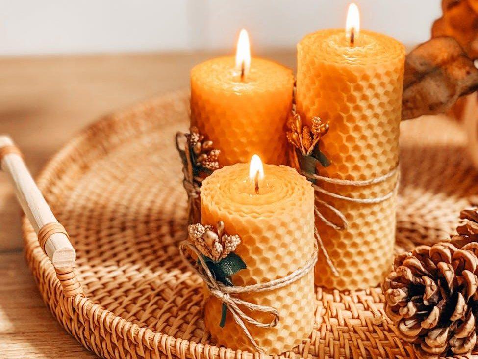 autumn decoration with beeswax candles pine cones and leaves on wicker tray