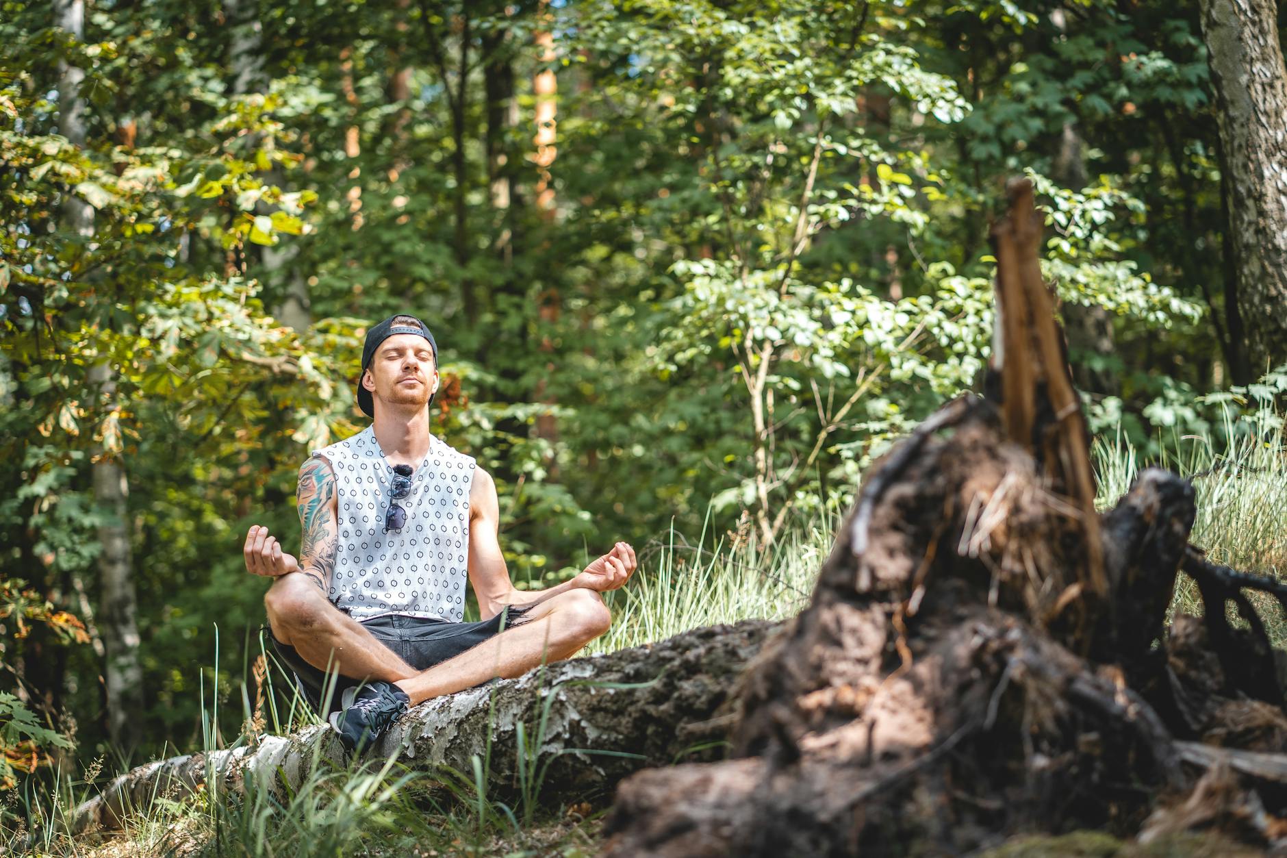 man meditating on a tree log, illustrating letting go in meditation practice for stress relief