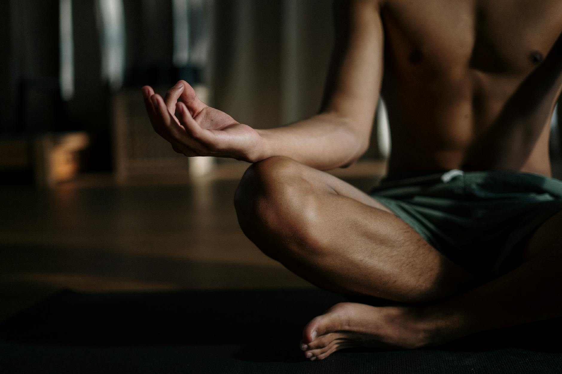man in black shorts sitting on floor in meditation practice