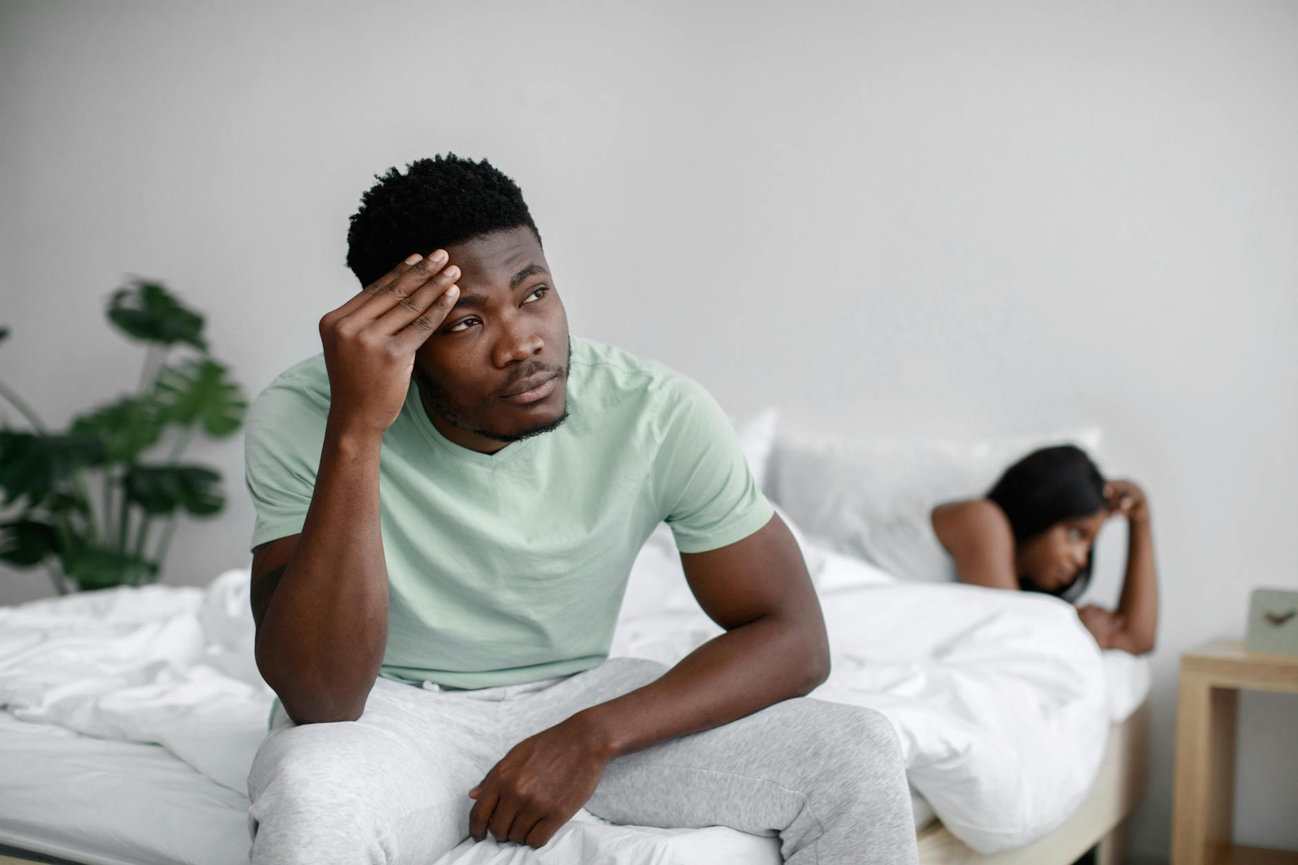 bickering couple on bed showing mindfulness techniques and emotional resilience in a paused argument