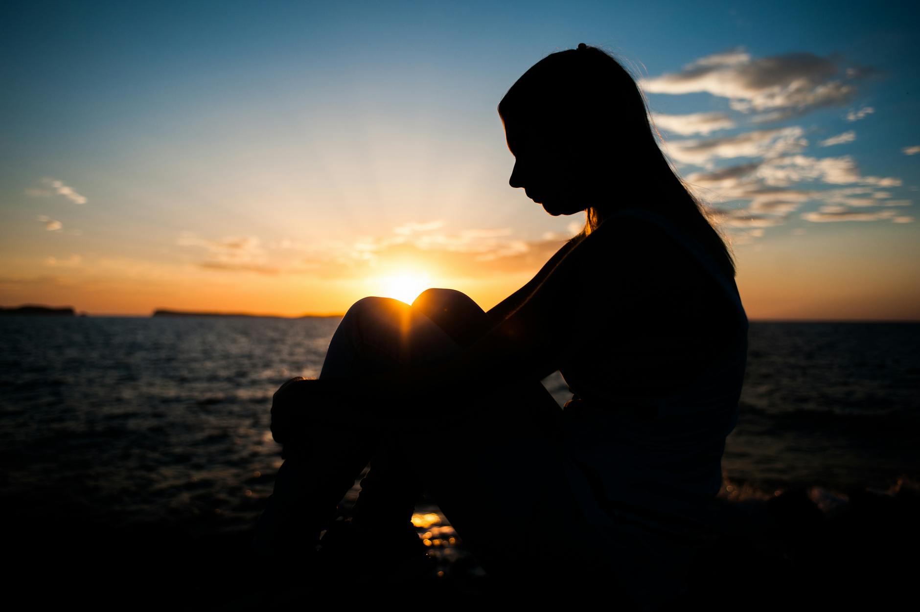 silhouette of person sitting outdoors, showing the benefits of mindfulness techniques and meditation practice