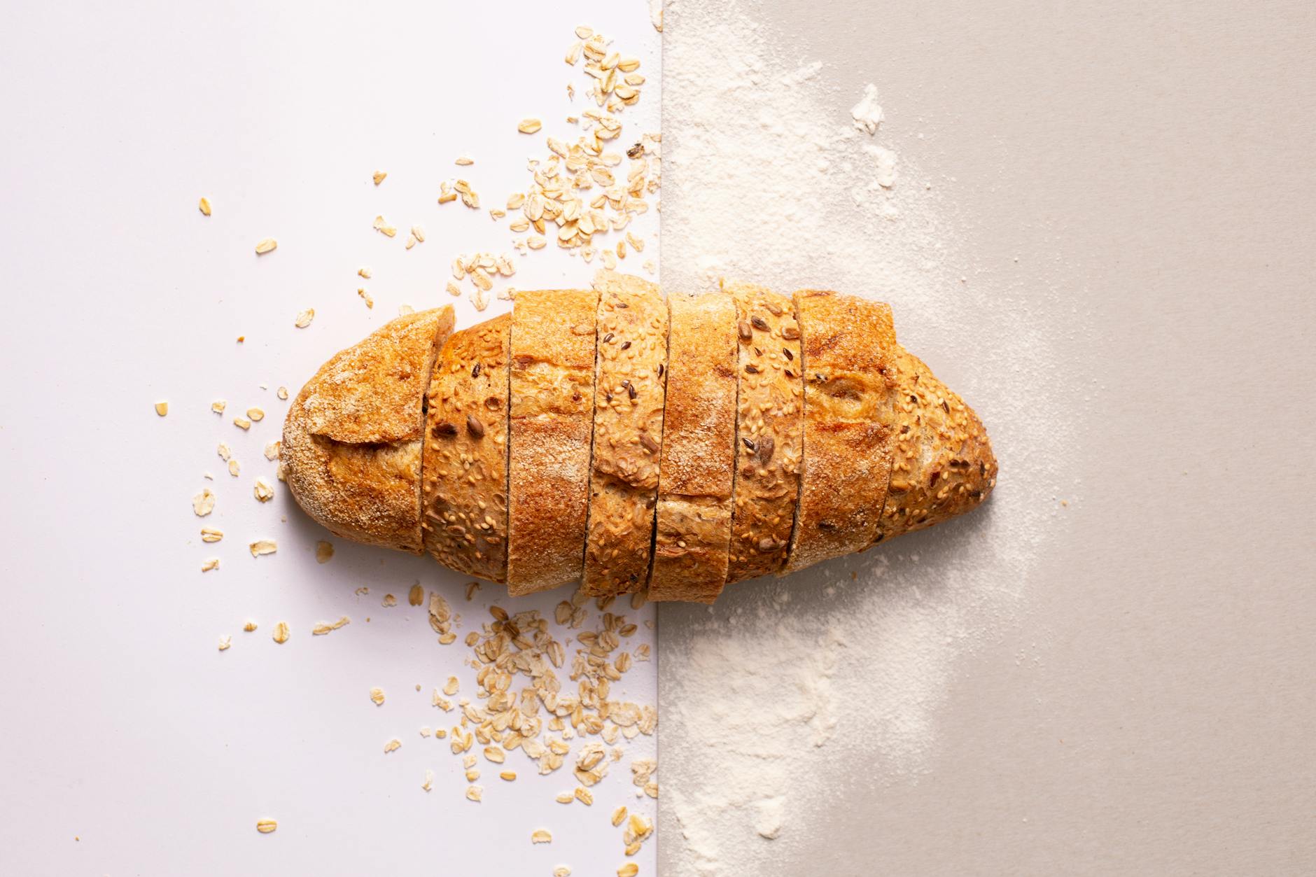 sliced bread on gray surface, inviting us to make sunflower seed bread, a summer solstice recipe for celebrating Litha as a kitchen witch