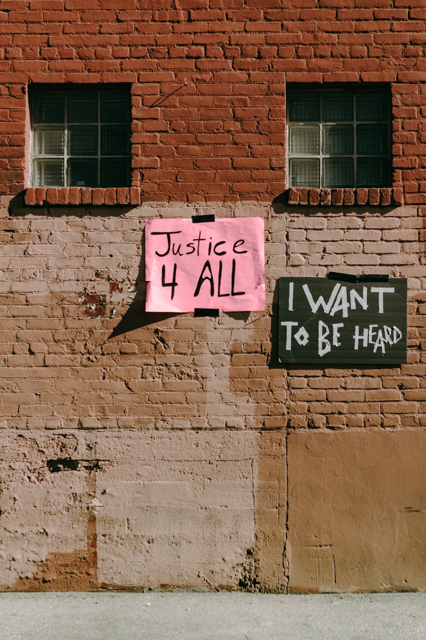 signs on a brick wall, begging consideration of wants vs needs and opportunities for peace via common ground during times of unrest