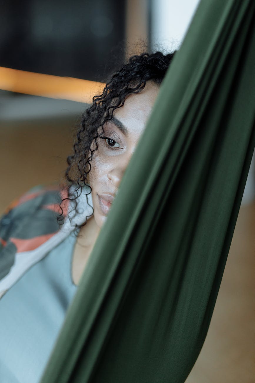 a woman sitting on green hammock, considering the benefits of digital minimalism and social media curation