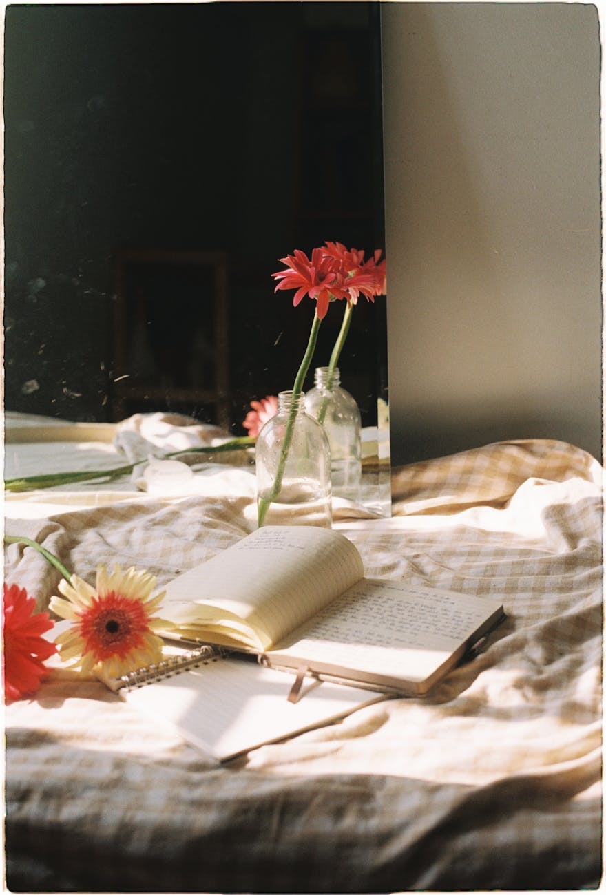 flowers and books on a bed, considering harvest reflections, tarot spread, first harvest celebration, seasonal self-inquiry, and summer sabbat ritual