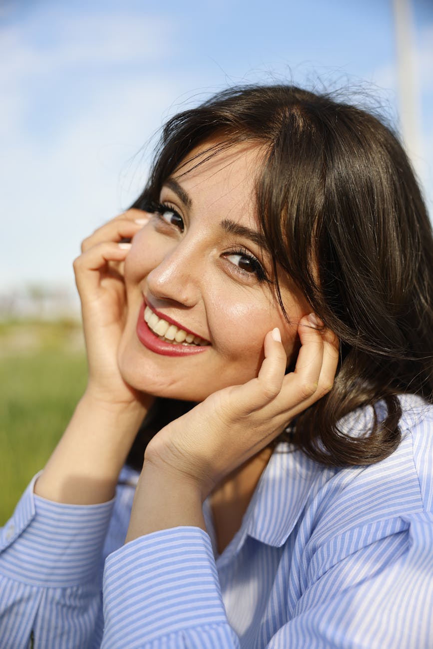 smiling woman posing with hands on cheeks, encouraging reclaiming sovereignty, overcoming conditioning and learned helplessness, gaining confidence and living with authenticity