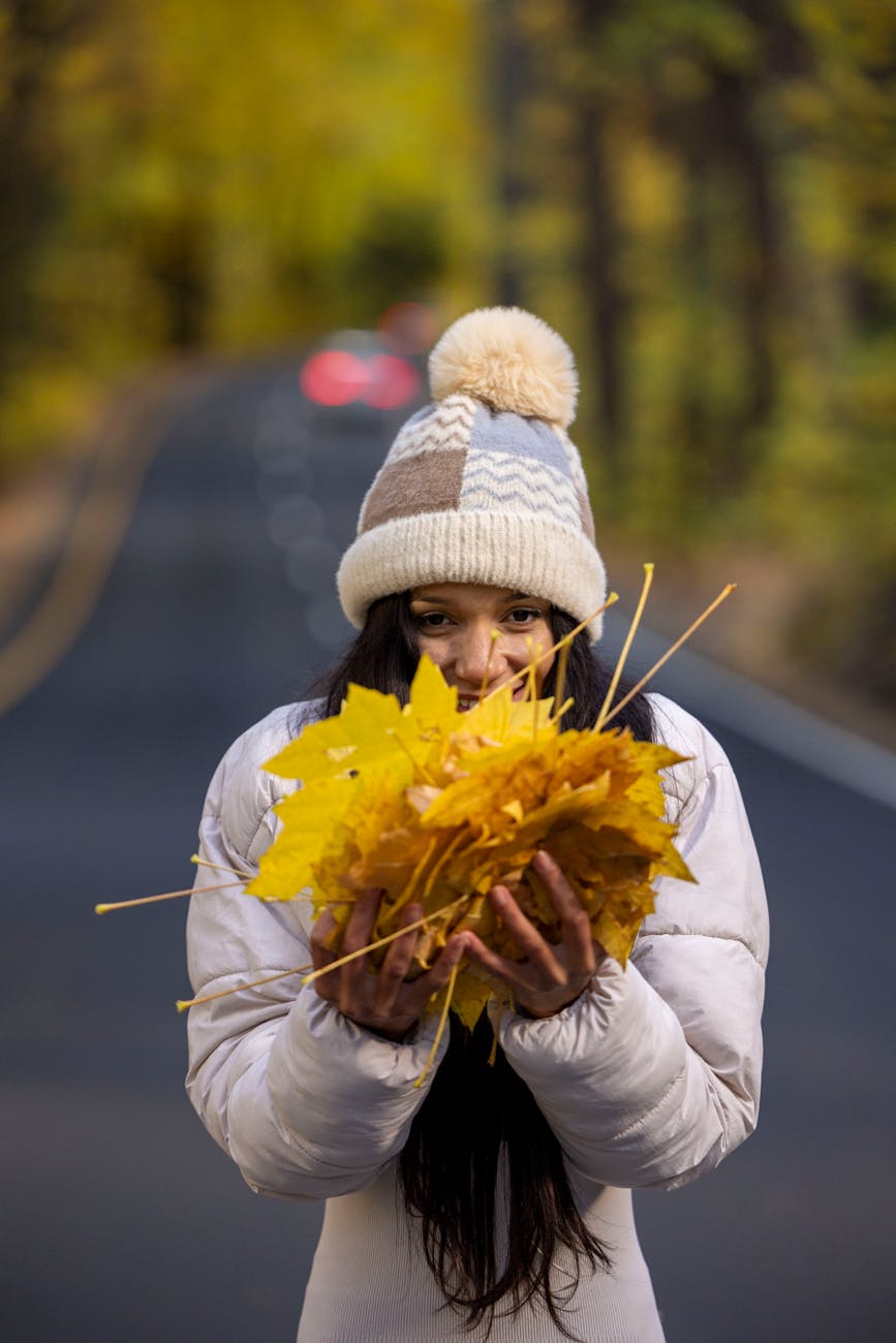 young woman enjoying autumn leaves on scenic road, considering spiritual connection, meditation practice, mindfulness and intuition, connect with higher self, and meditation for inner peace