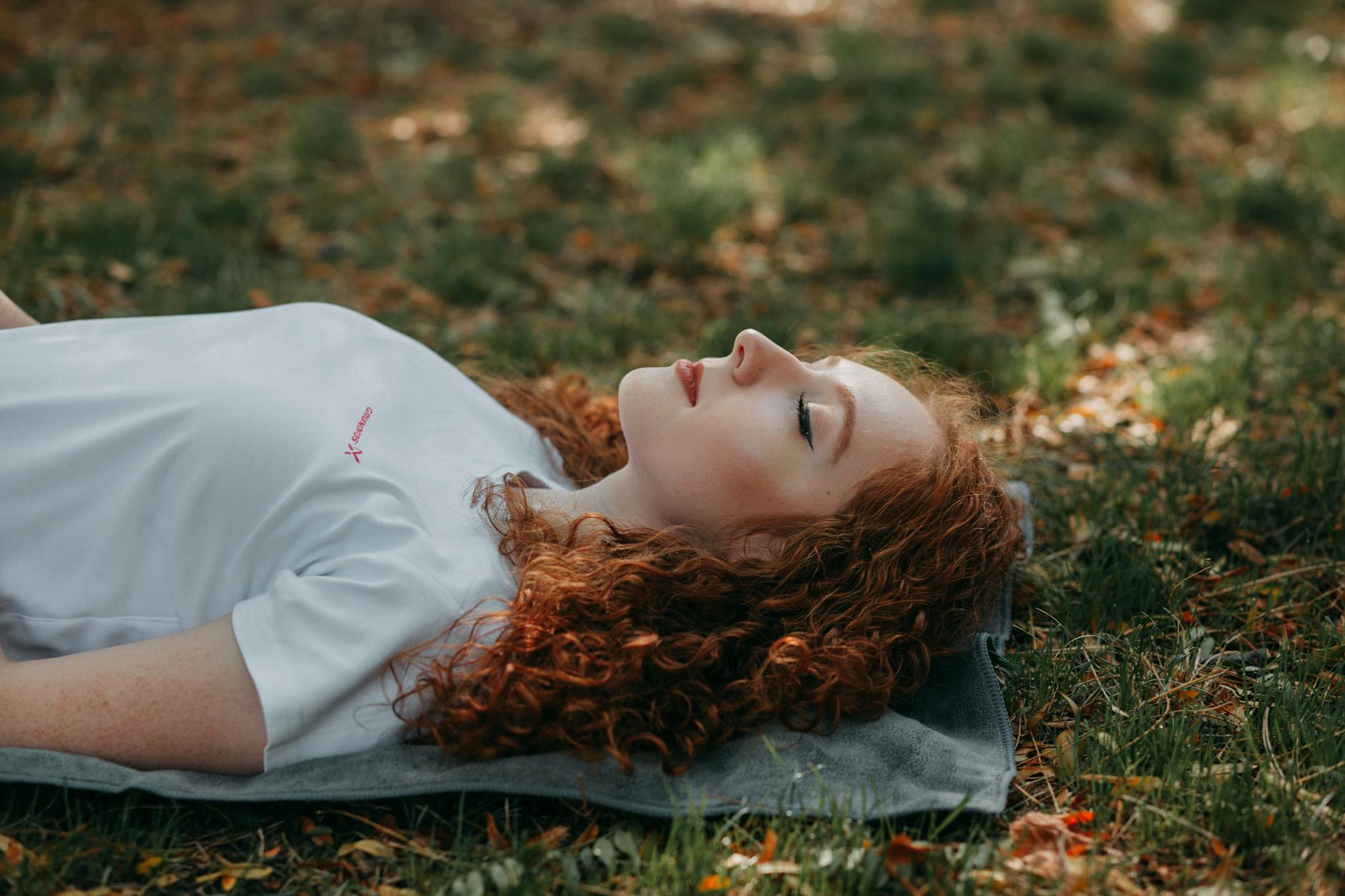 photo of woman laying on ground, considering personalized meditation, meditation goals, stress reduction, daily mindfulness, and meditation practice