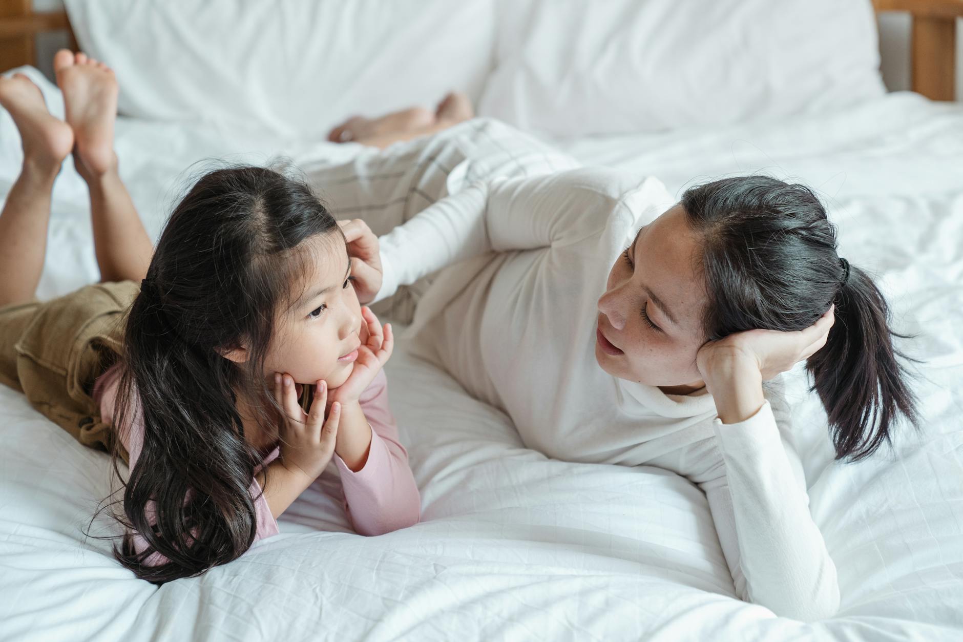 photo of woman and girl talking while lying on bed, practicing mindfulness, mindfulness in relationships, mindfulness at work, mindful communication, and daily mindfulness