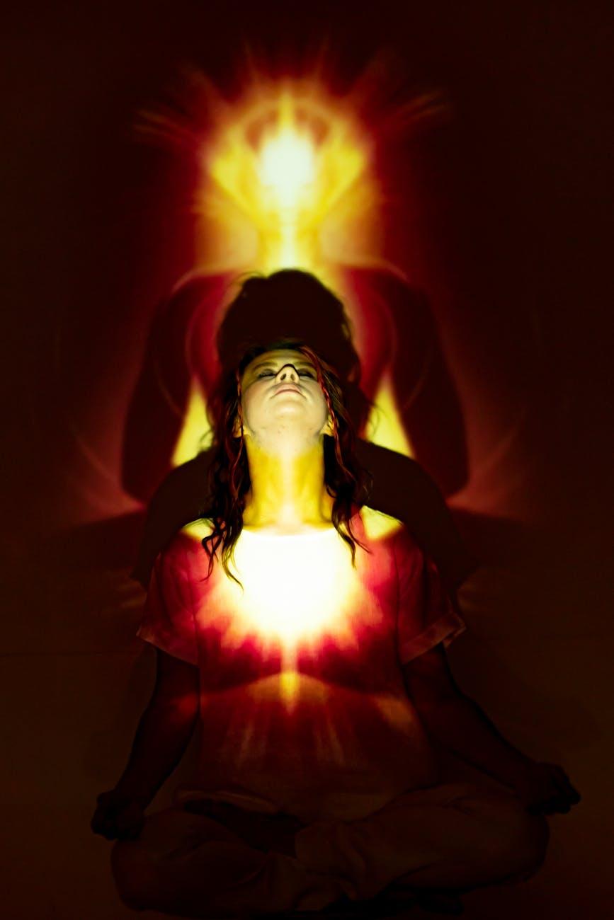 woman in red dress with red light, considering spiritual connection, meditation practice, mindfulness and intuition, connect with higher self, and meditation for inner peace