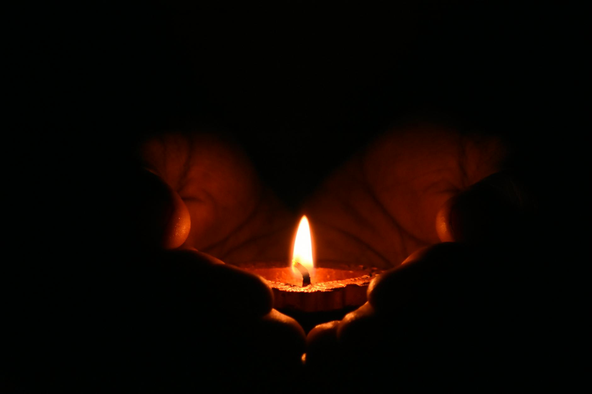 tealight candle on human palms, encouraging reclaiming sovereignty, overcoming conditioning and learned helplessness, gaining confidence and living with authenticity