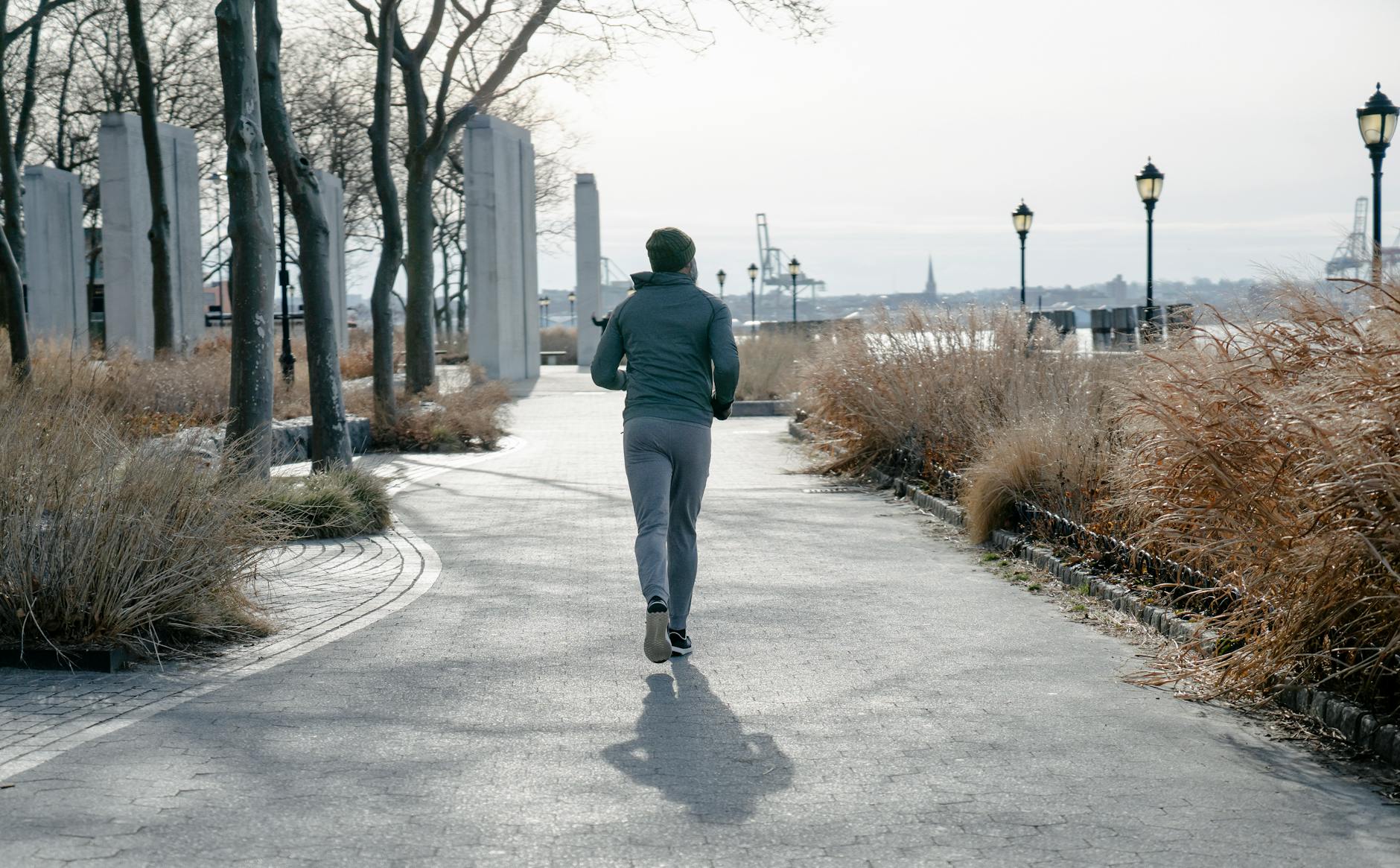 anonymous man in sportswear running on path in park, considering meditation hurdles, consistent practice, sustain mindfulness, meditation obstacles, and how to meditate consistently.