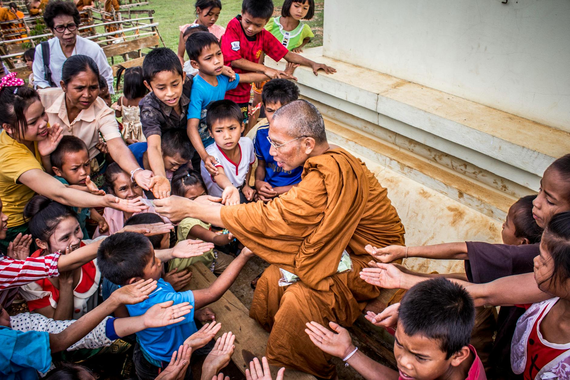 monk surrounded by children, considering spiritual connection, meditation practice, mindfulness and intuition, connect with higher self, and meditation for inner peace