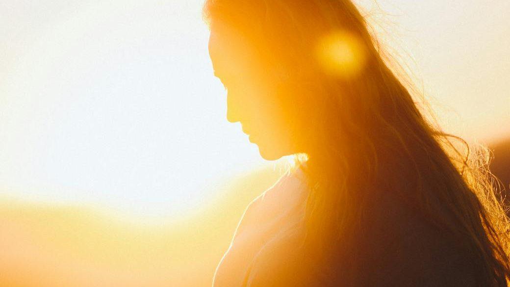 woman in black shirt during sunset, encouraging reclaiming sovereignty, overcoming conditioning and learned helplessness, gaining confidence and living with authenticity