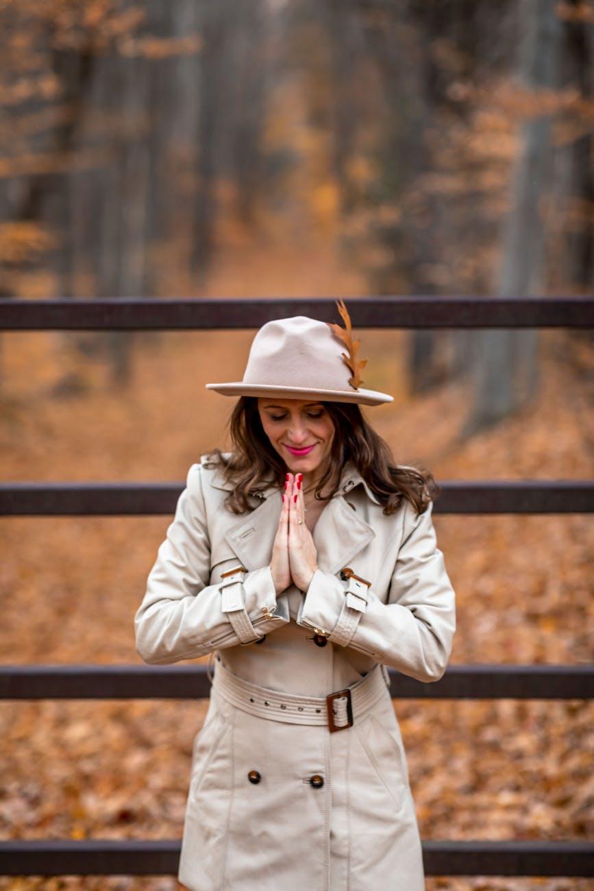 a woman in a coat praying, evoking advanced meditation techniques, deep meditation practice, meditation journey, advanced mindfulness, and spiritual growth meditation
