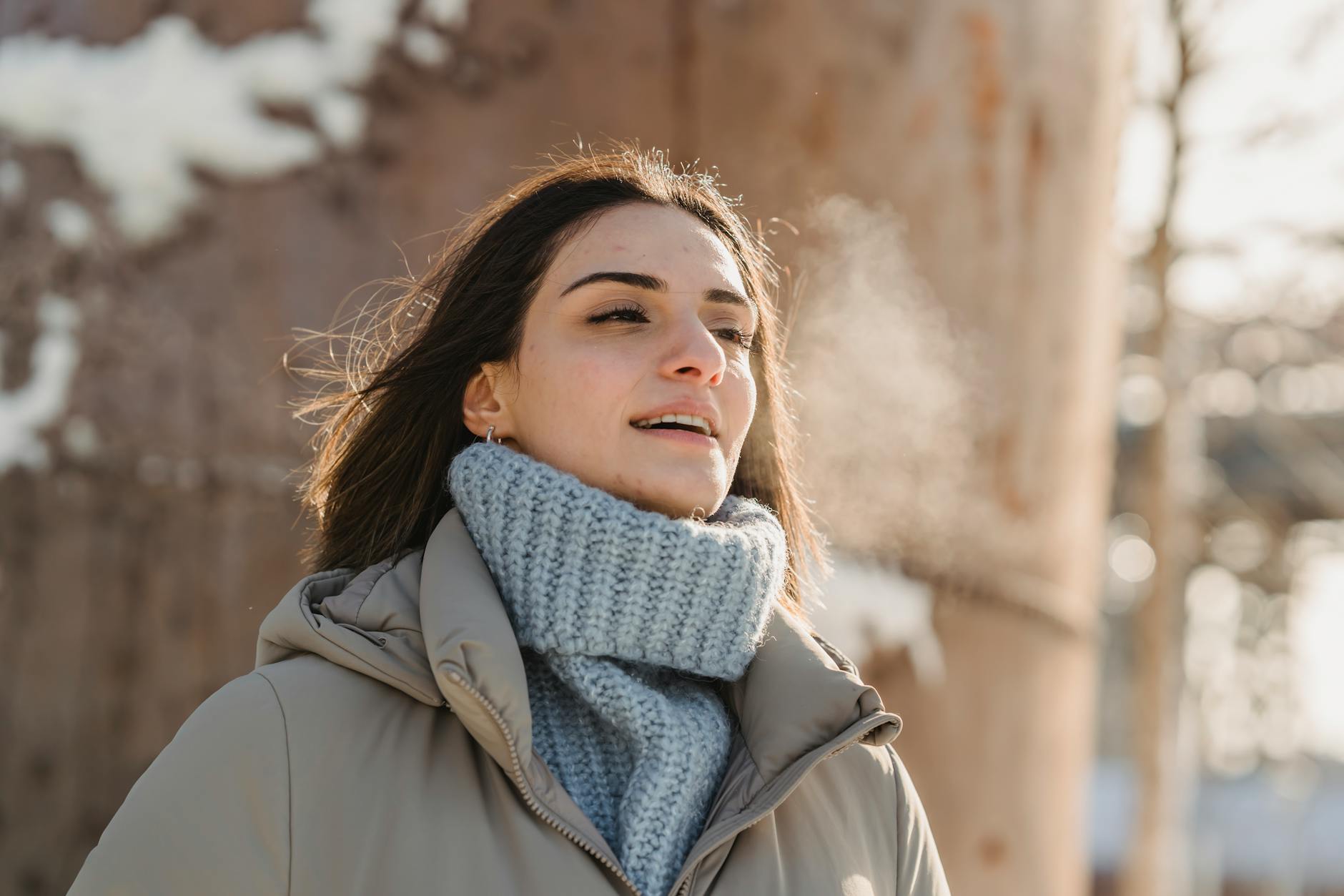 young woman exhaling steam on freezing cold weather, illustrating Pranayama, breathing techniques, breath control for meditation, meditation for energy and calm, and advanced breathing exercises