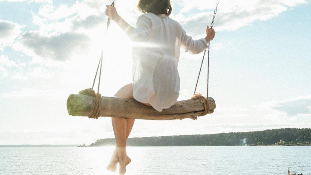 a woman in white long sleeves sitting on the swing, evoking advanced meditation techniques, deep meditation practice, meditation journey, advanced mindfulness, and spiritual growth meditation
