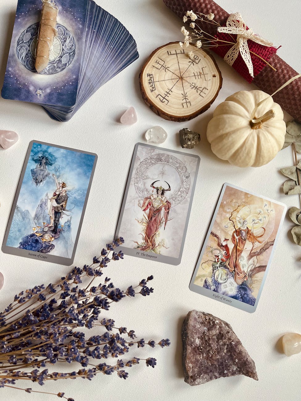 view of tarot cards flowers and crystals lying on a table, illustrating: Mabon divination, inner wisdom, Tarot spread, harvest reflection, and the Autumn Equinox