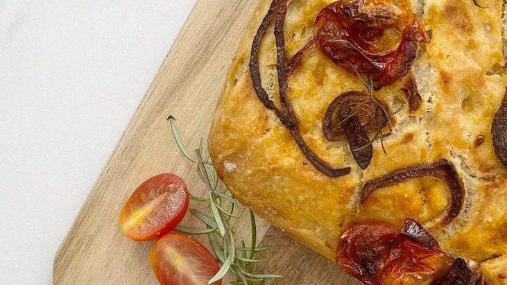 focaccia on a wooden board, illustrating: Mabon celebration, harvest bread recipe, autumn equinox recipes, seasonal bread, and a focaccia recipe