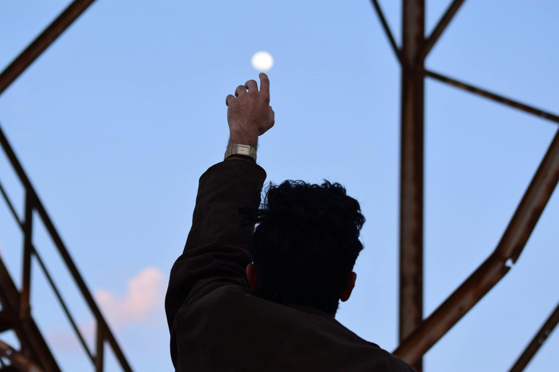 man reaching hand towards moon, showing: moon effects on humans, lunar rhythms, lunar phases and emotions, moon influence science, and moon biological rhythms