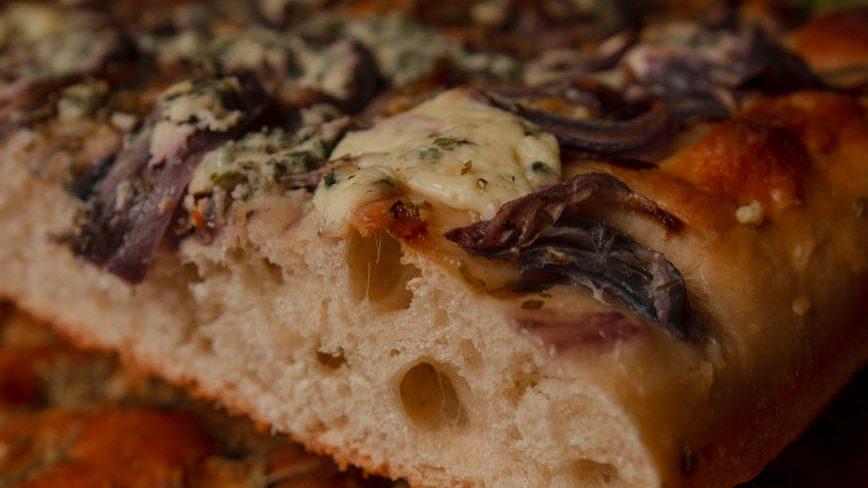 close up of freshly baked artisan focaccia bread, illustrating: Mabon celebration, harvest bread recipe, autumn equinox recipes, seasonal bread, and a focaccia recipe