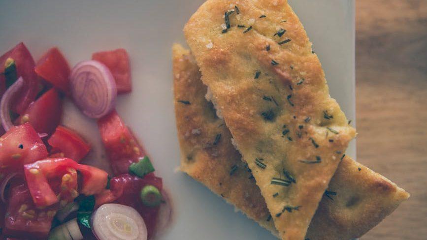 sliced pizza on white ceramic plate, illustrating: Mabon celebration, harvest bread recipe, autumn equinox recipes, seasonal bread, and a focaccia recipe