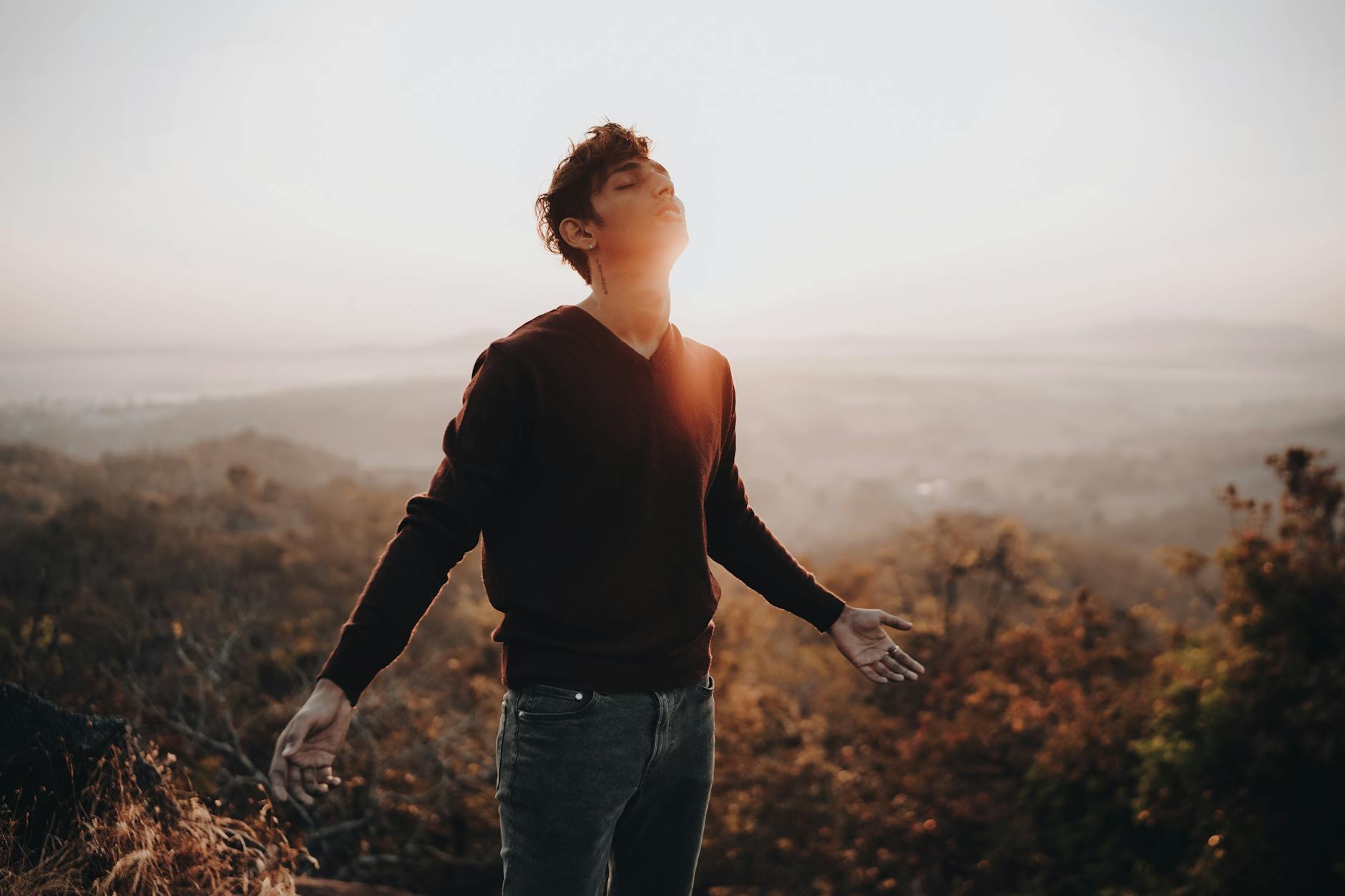 man standing on mountain in back lit