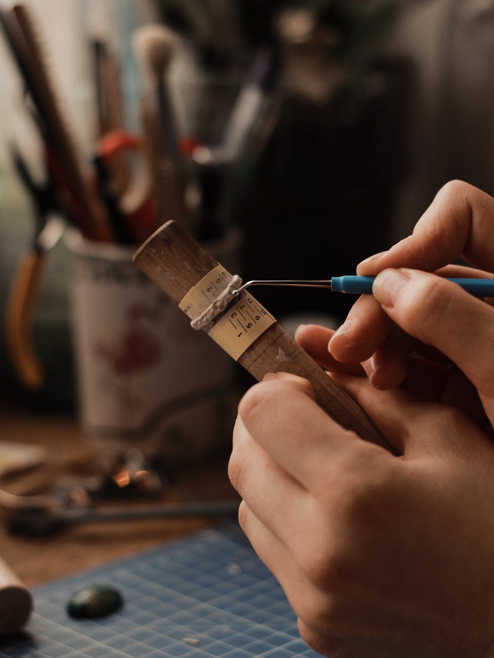 person holding blue and silver hand tool