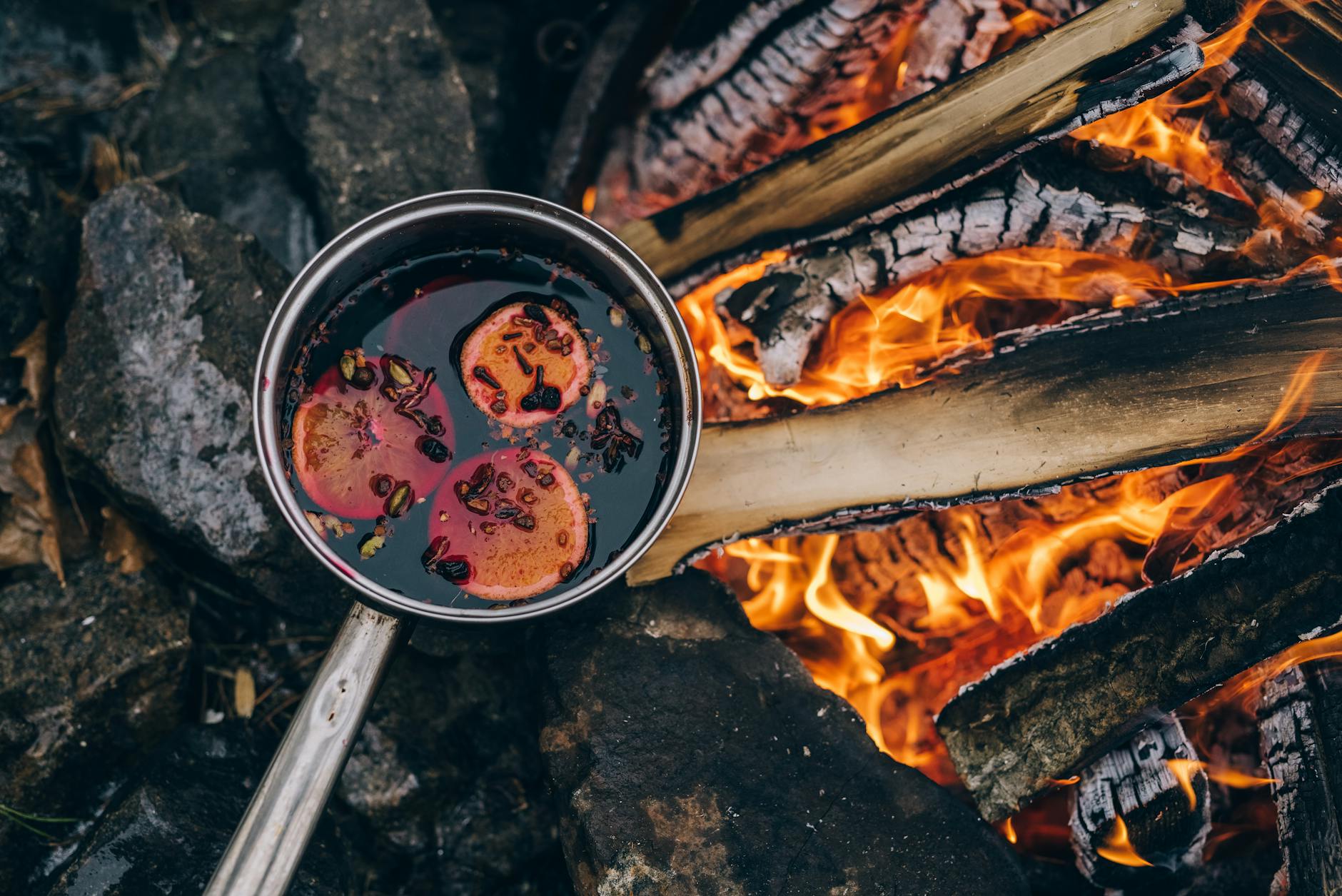 steel pot near the bonfire, evoking: a Samhain wassail recipe, warm mulled cider, Samhain ritual drink, harvest blessing wassail, and an ancestors Samhain toast