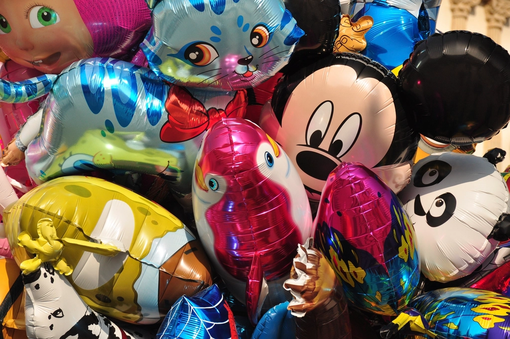 Disney character balloons, amusement park, evoking: New Year, Full Moon, Cancer energy, new beginnings, and layers of change