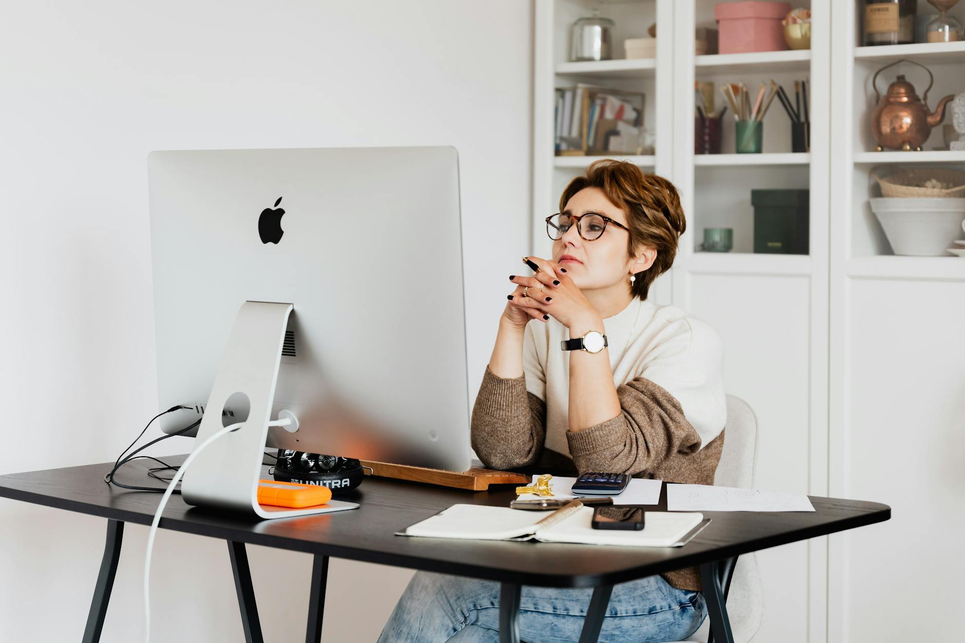 focused female employee reading information on computer in office, illustrating: Aquarius, visionary, Hellenistic Astrology, Zodiac Signs, and Aquarius Season