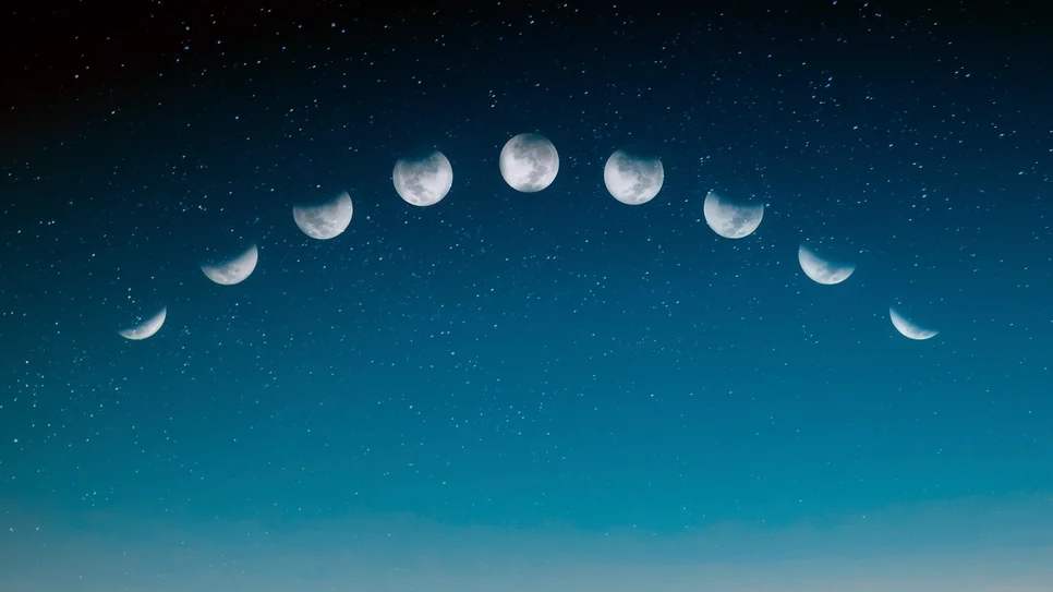 moon phases in a night sky above a boy on a bench who's pointing up at them; evoking: astrology, planetary transits, zodiac signs, birth chart, and moon phases