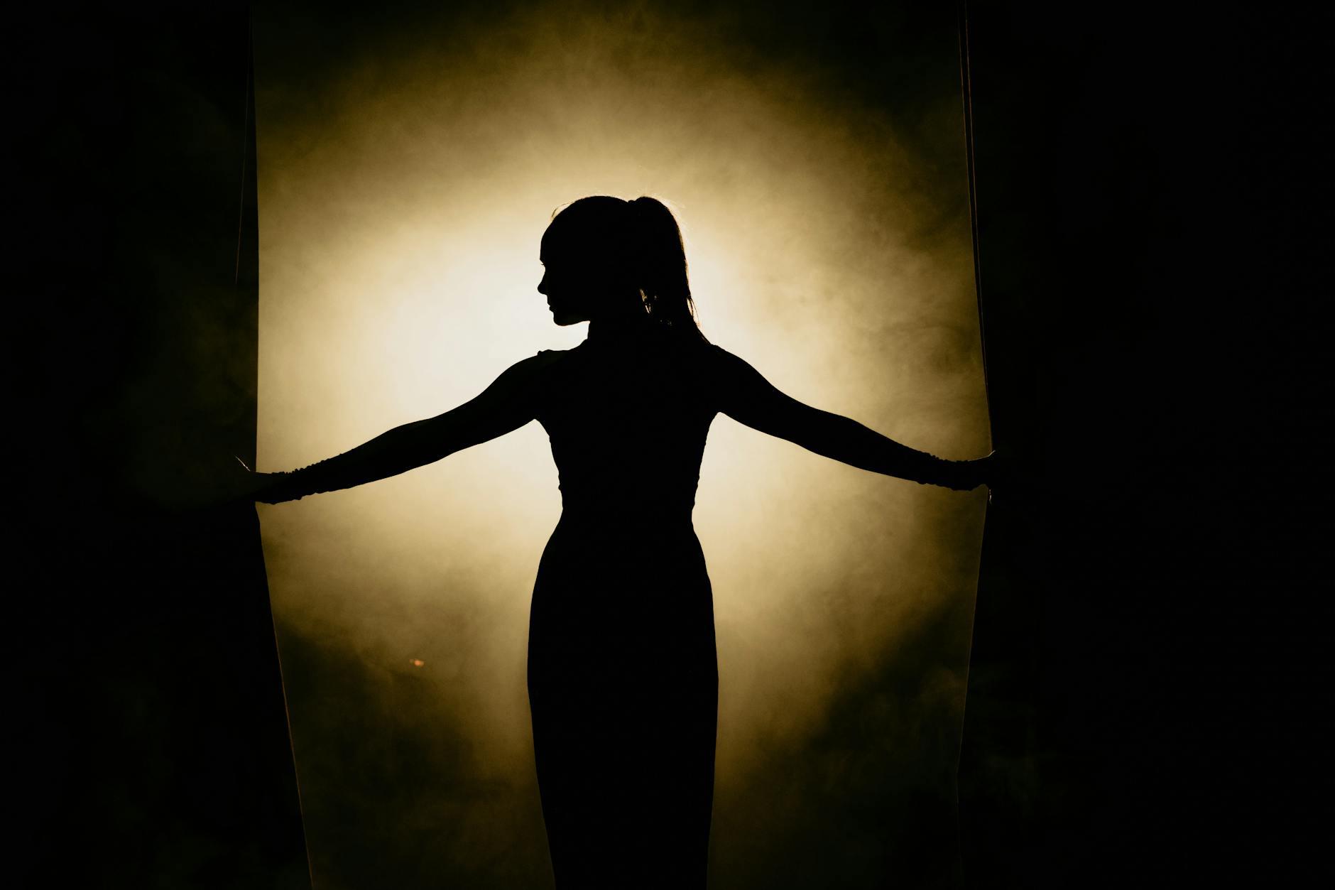 silhouette of woman standing on stage, evoking: astrology, natal chart, aspects, transits, and returns
